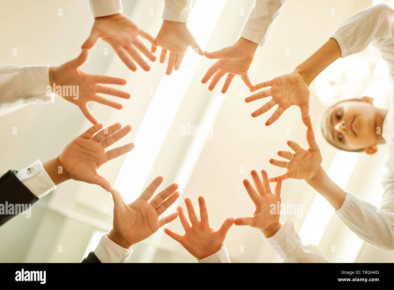 Business Kinder in einem Kreis mit ausgestreckten Händen für Teambuilding und Zusammenarbeit Stockfoto