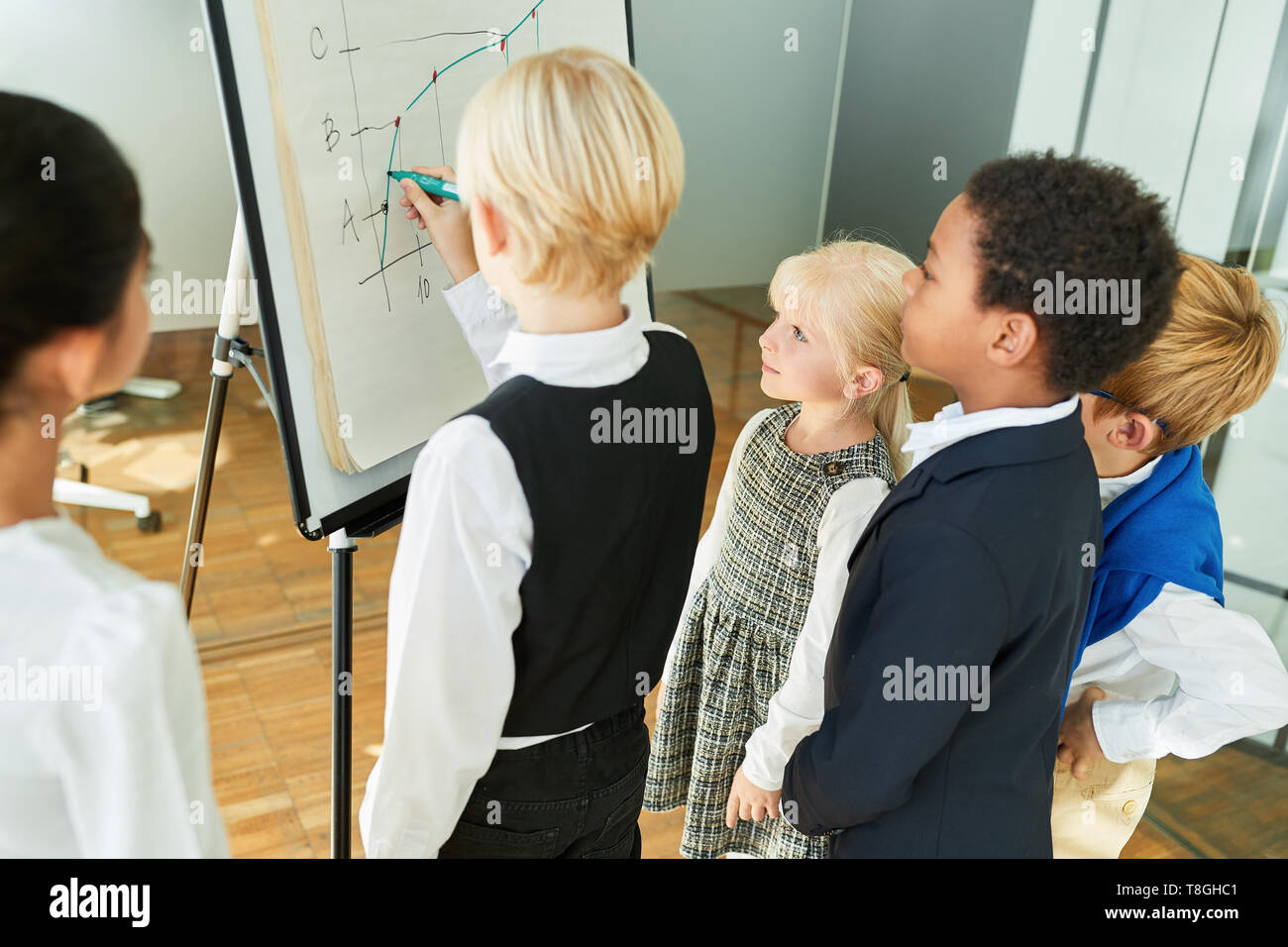 Kinder Verkleidung als Unternehmer bei einer Präsentation auf dem Whiteboard im Büro Stockfoto