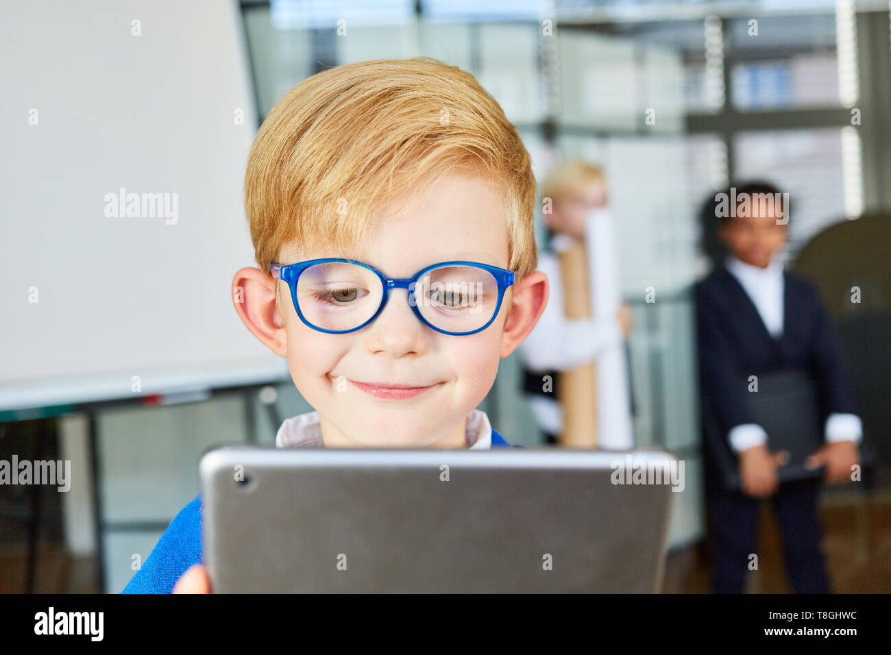 Lächelnd Kind mit einem Tablet-PC in der Grundschule Stockfoto