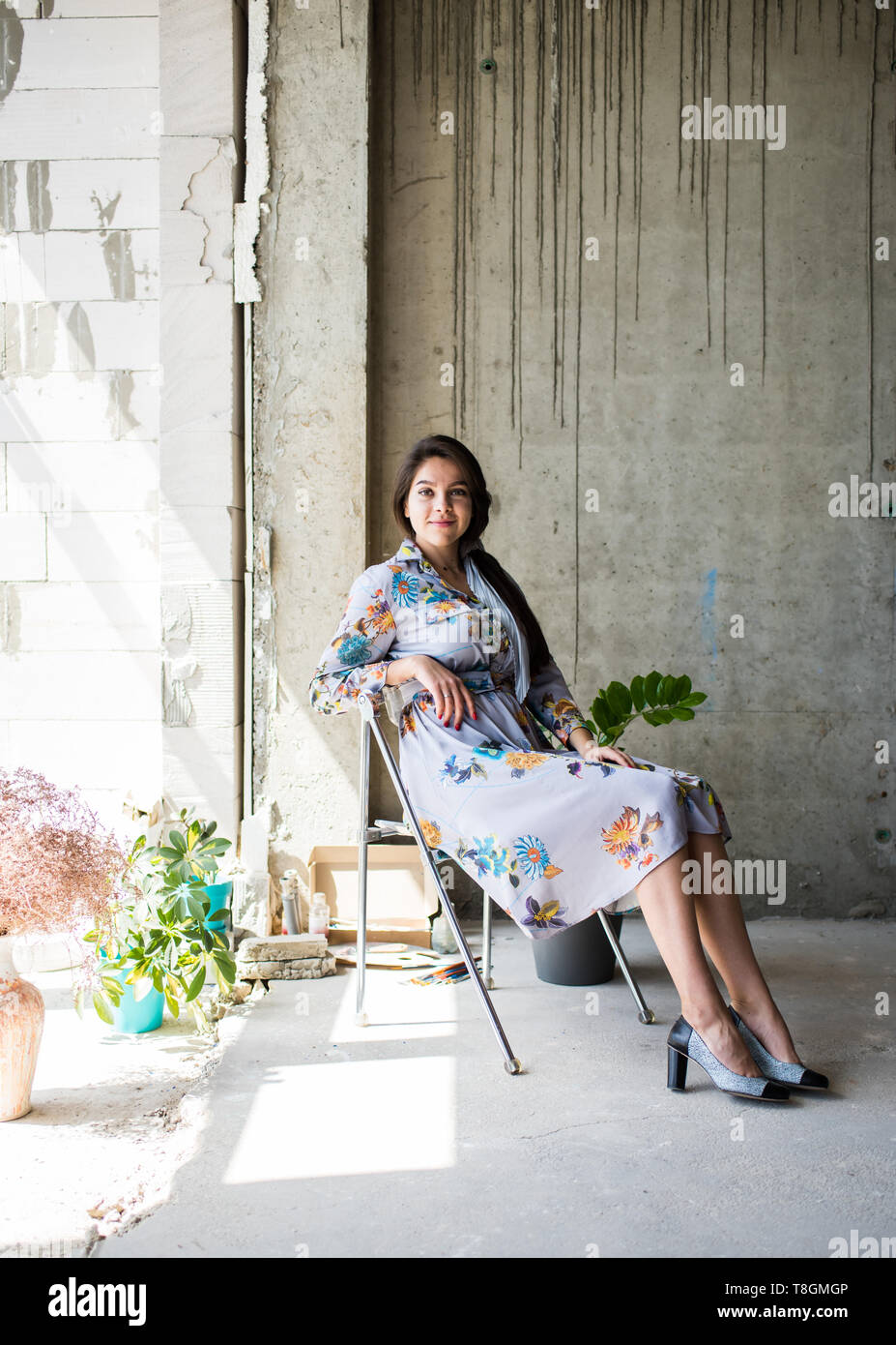 Schöne junge Dame Künstler in ihrem Böhmischen künstlerische Studio Loft sitzen Stockfoto