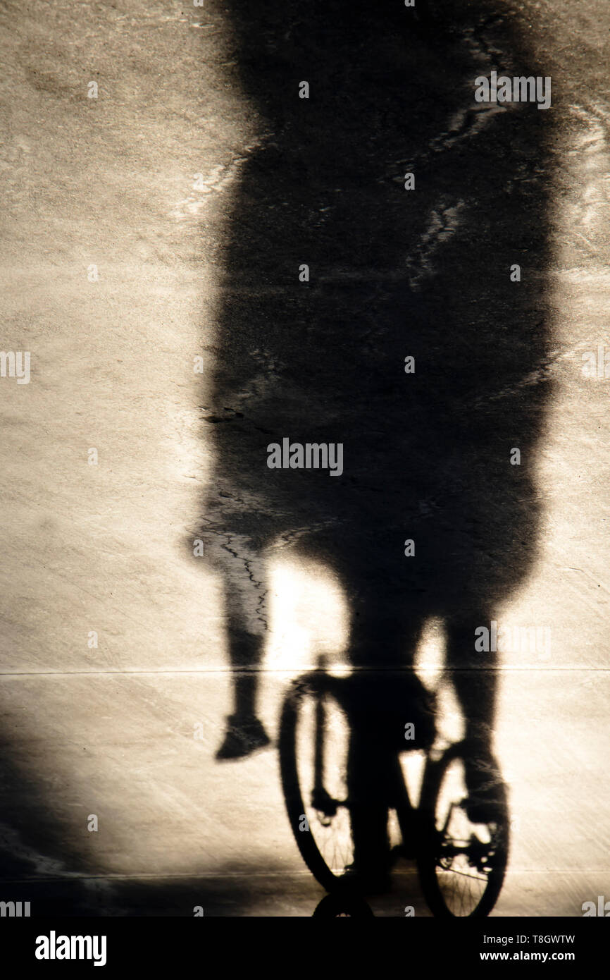 Absract verschwommene Schatten von zwei Freunden zusammen reiten auf einem Fahrrad, einem sitzen auf Lenker Stockfoto