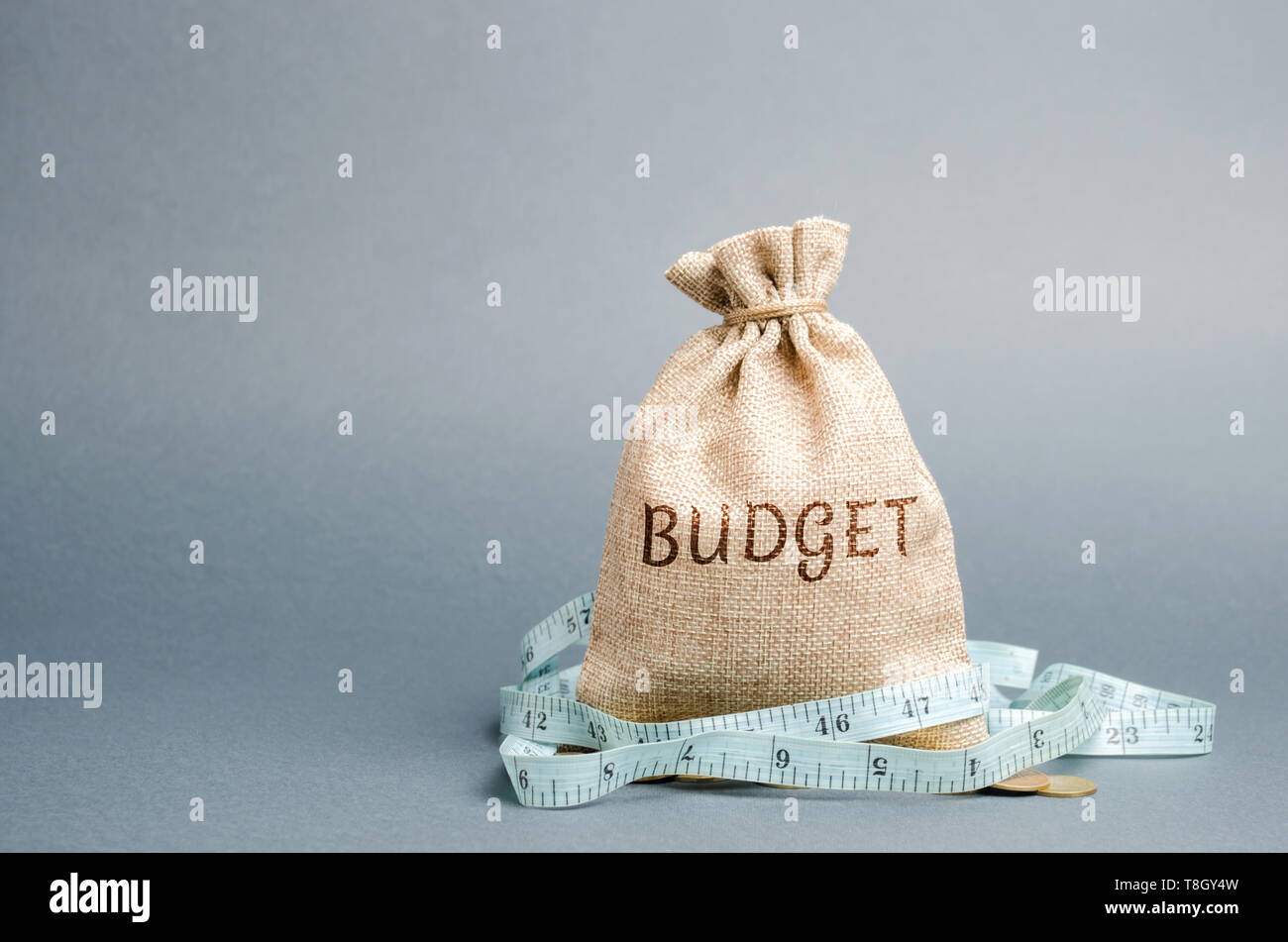 Beutel mit Geld und Maßband und das Wort Haushalt. Begrenztes Budget. Der Mangel an Geld. Das Konzept der Akkumulation von Geld in der Familie Haushalt. Familie ins Stockfoto