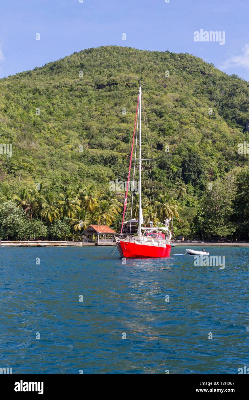 Martinique, Karibik, schwarz Cove mit dem Ponton und schwarzem Sand Strand, vor Anker eine rote Segelboot Stockfoto