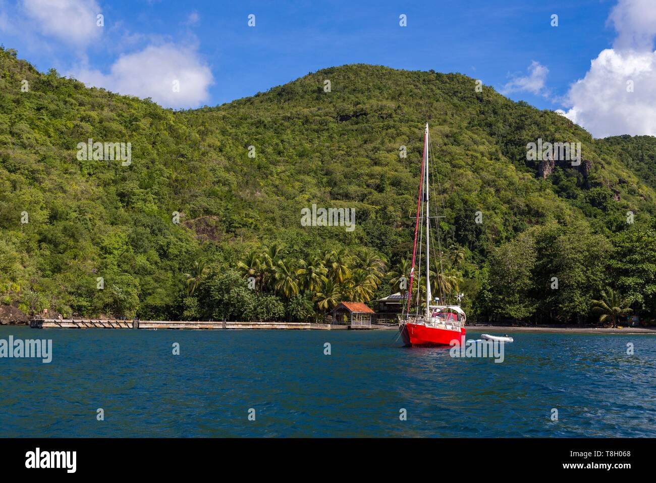 Martinique, Karibik, schwarz Cove mit dem Ponton und schwarzem Sand Strand, vor Anker eine rote Segelboot Stockfoto