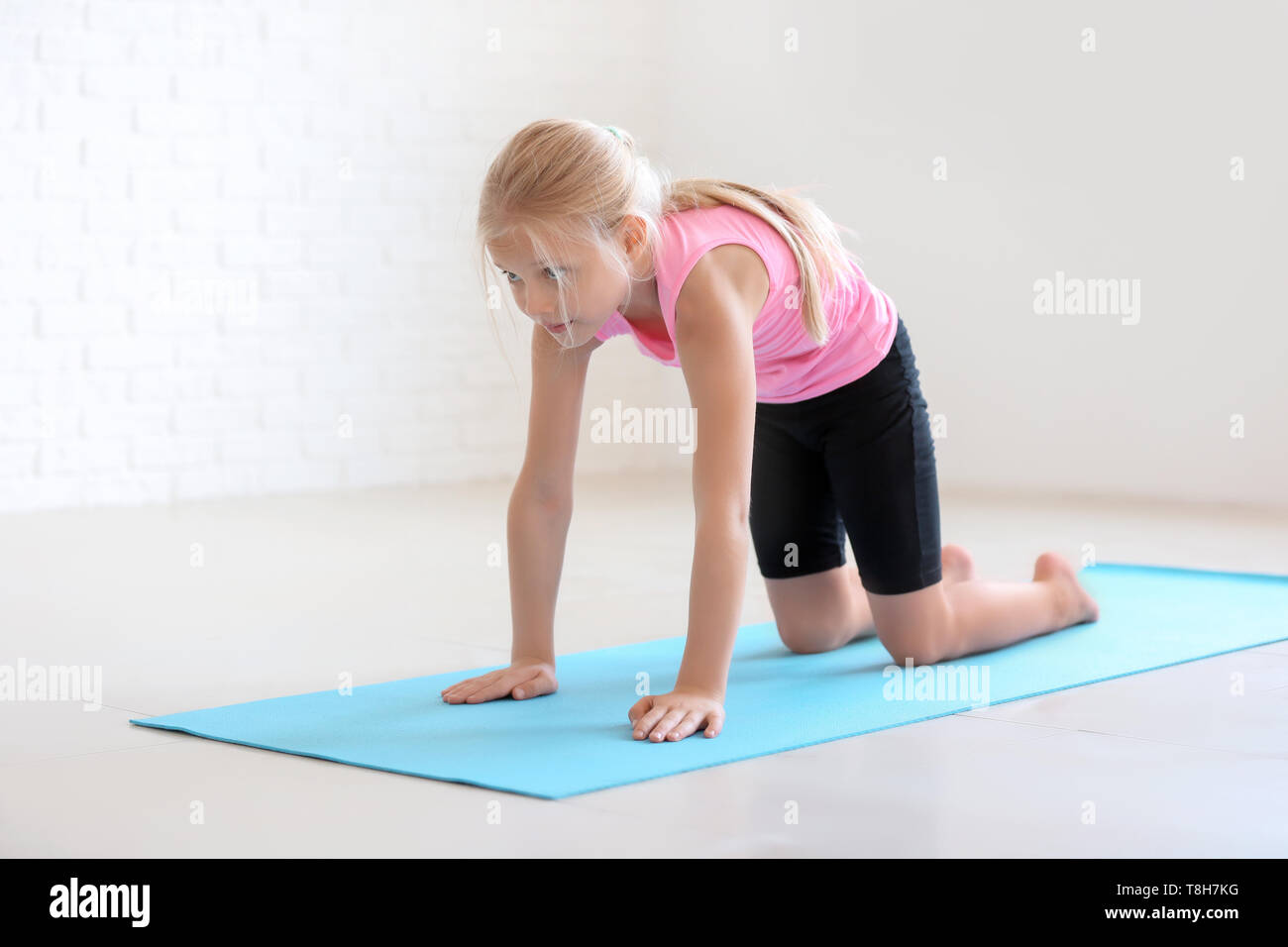 Kleines Mädchen üben Yoga im Innenbereich Stockfoto