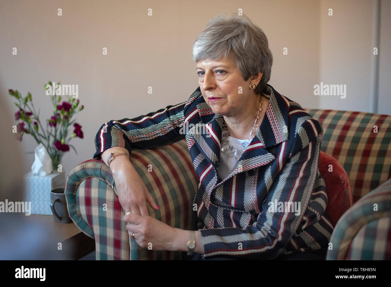 Premierminister Theresa können Gespräche mit einem Fall Arbeitnehmer und Überlebenden (weder identifiziert werden können) im Voraus Liebe Büros in West London, wo Sie Unterstützung für Opfer häuslicher Gewalt diskutiert. Stockfoto