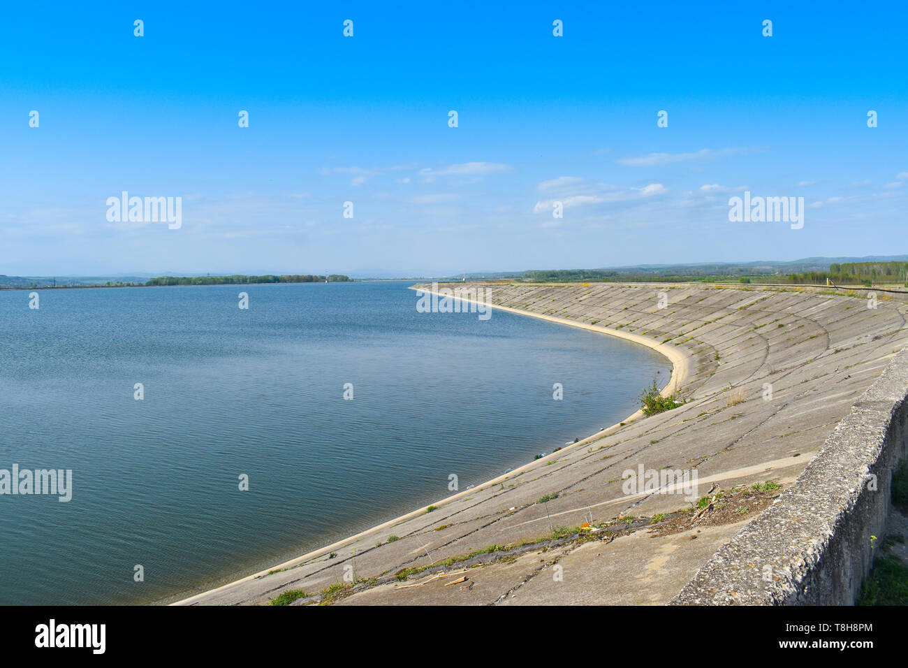 Staudamm am Fluss Olt an einem sonnigen Frühlingstag. Wasserkraftwerkes am künstlichen See. Stockfoto