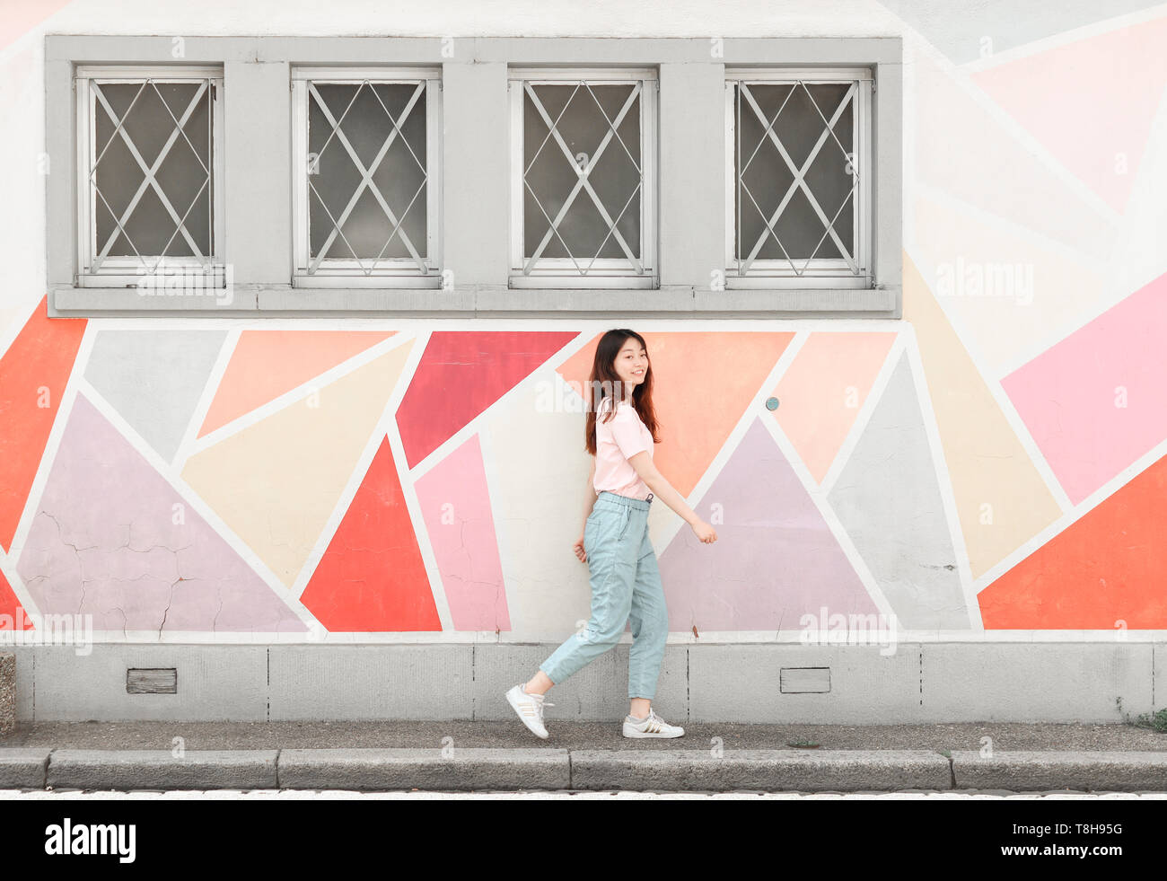 Junge Frau und eine bunte geometrische Wall Design Stockfoto