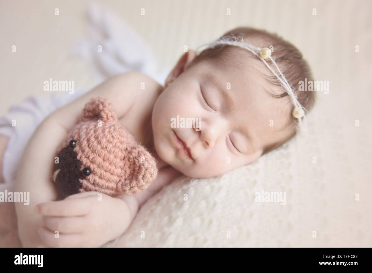 Neugeborenes Mädchen slepping Holding ein Teddybär Stockfoto