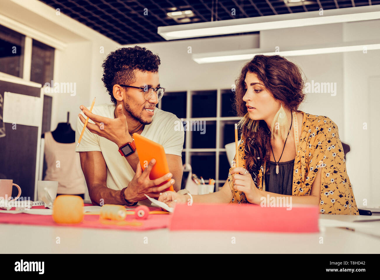 Jungen Mitarbeiter diskutieren ihre Ideen in einem Studio. Stockfoto
