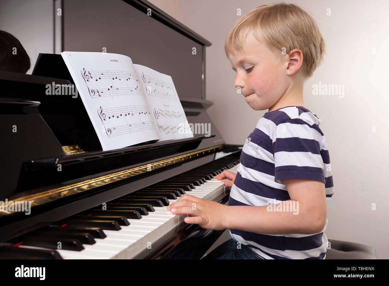 Junge, 4 Jahre, Klavier spielen, mit Konzentration Stockfoto