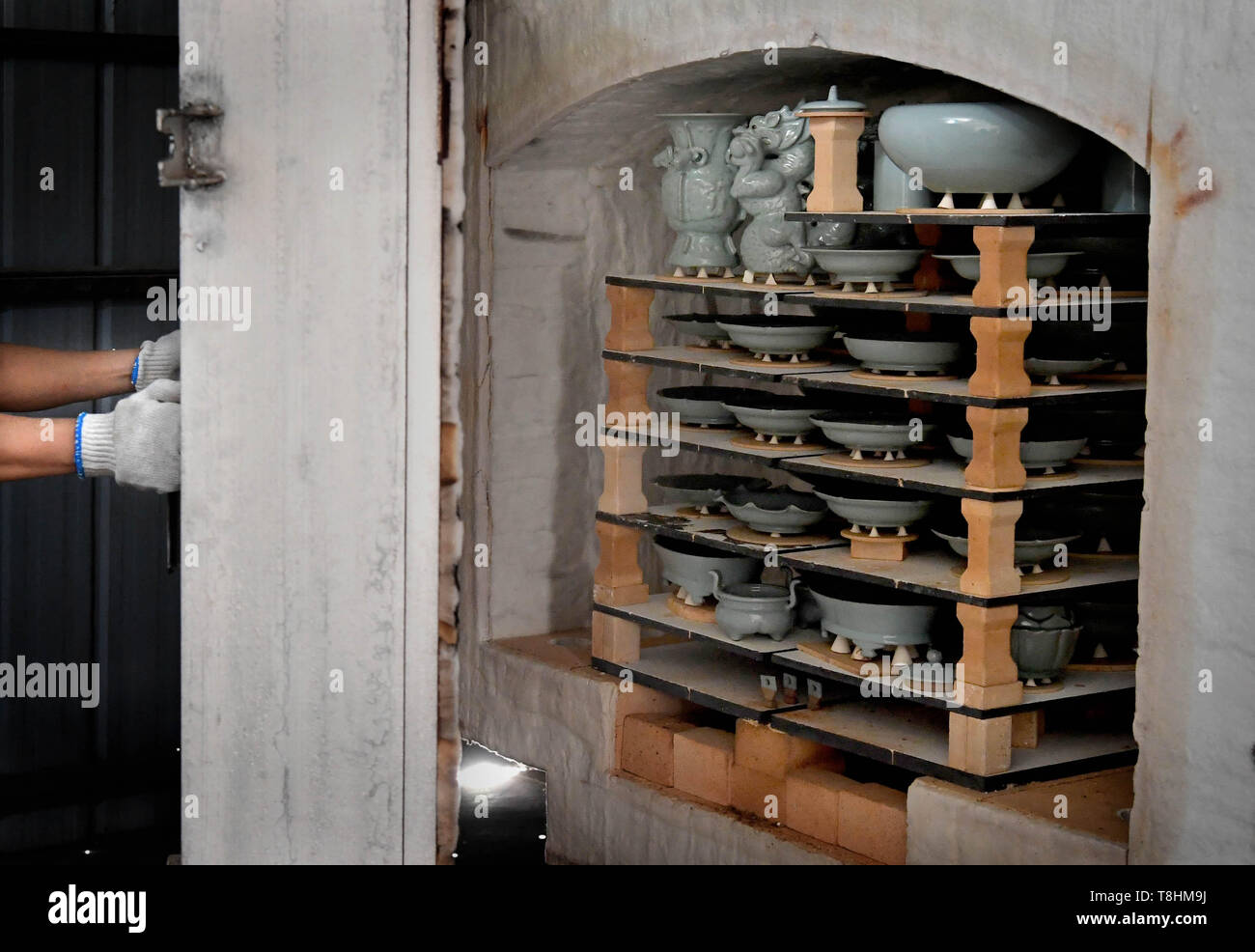 (190513) - Peking, 13. Mai 2019 (Xinhua) - Wang Junzi öffnet Ru Porzellan Ofen in seinem Studio in Qingliangsi Dorf, baofeng Grafschaft von der Central China Provinz Henan, 9. Mai 2019. Ru Porzellan, einer der fünf bekannten Arten von Porzellan während der Song Dynastie (960-1279) im alten China, ist für seine azurblaue Farbe bekannt, leichten Körper, zarte Korn und sanften Textilien. Wang Junzi, geboren 1960, ist ein Ru Porzellan feuern Handwerker in Qingliangsi Dorf Baofeng Grafschaft in der zentralen China Henan, wo die alten offiziellen Ru Porzellan Ofen in der Song Dynastie befindet. Um die Beau reproduzieren Stockfoto