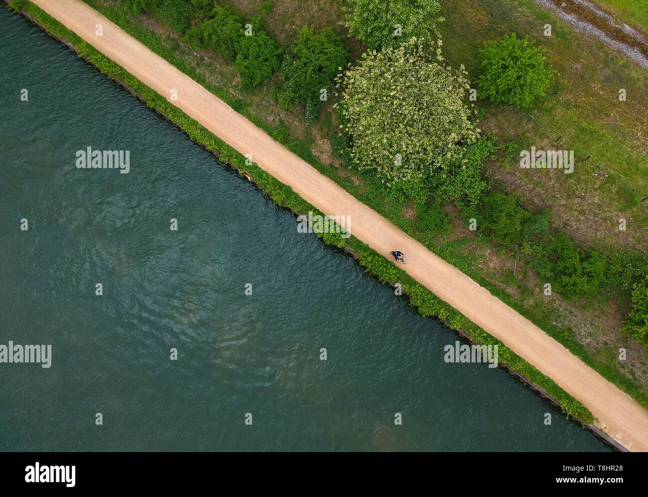 (190513) - ESSEN, 13. Mai 2019 (Xinhua) - luftaufnahme am 10. Mai 2019 zeigt ein Bürger mit dem Fahrrad entlang der Emscher in Essen, Deutschland. Im Ruhrgebiet, eine Basis- und Ladestation für die Eisen- und Stahlindustrie in Nordrhein-Westfalen, Deutschland, Essen, sah eine grüne Übergang der Industrie in den vergangenen Jahren. Einmal stark belastet, Essen hat sich in einen sauberen und Kulturzentrum umgewandelt. Derzeit sind rund 68 % der Flächen in Essen hat aufgeforstet worden. Während der Beijing Internationale Gartenbauausstellung, der Deutsche Pavillon stellt, wie grüne Initiativen und Projekte dazu beigetragen, die Umwelt wiederherstellen Stockfoto