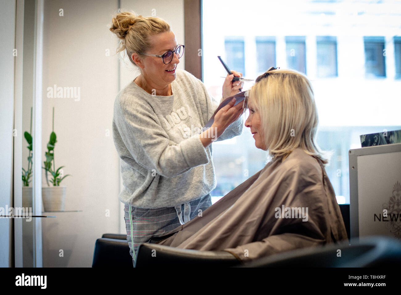 Kassel, Deutschland. 30 Apr, 2019. Sandra Hilpert, master Friseur und  Betreiber des Salon chicke Schnitte', hairdresses Kunden Petra Reitze. Rund  20 Friseursalons in eine Straße im Stadtteil Vorderer Westen besiedelt.  Credit: Swen