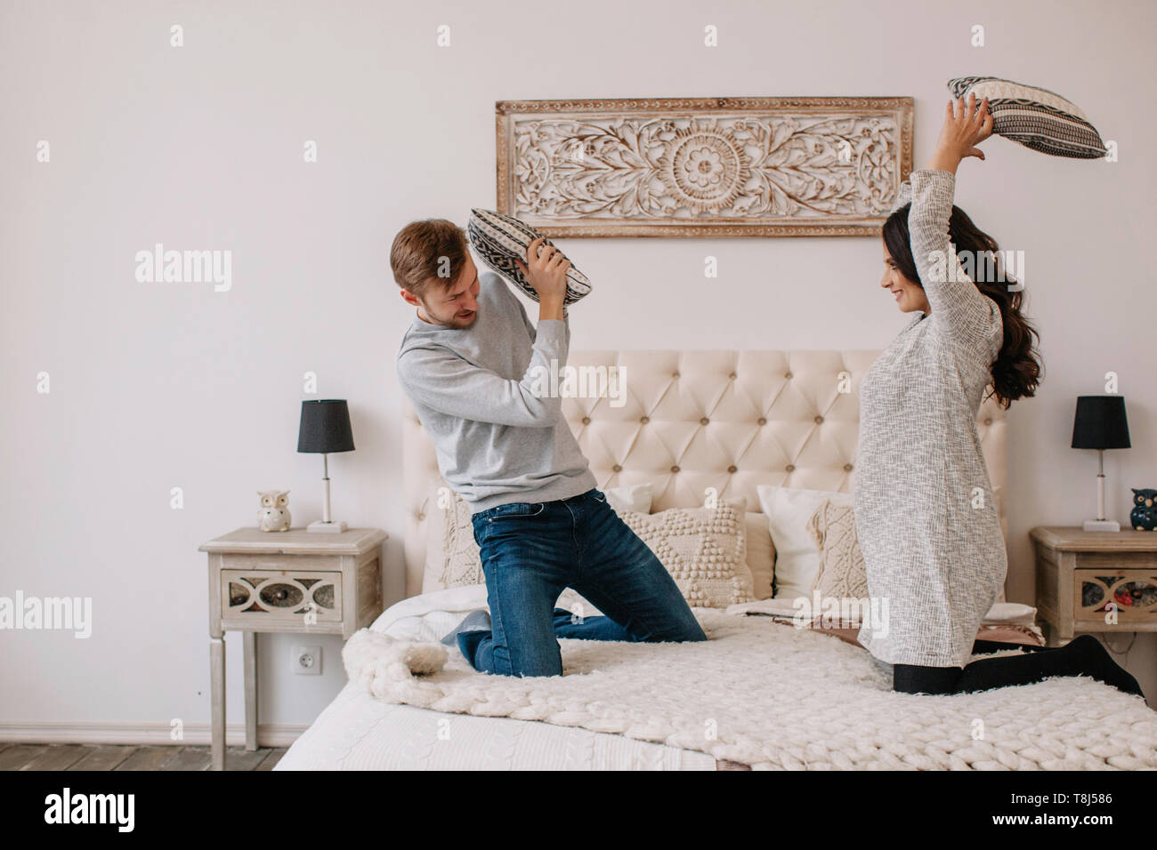 Paar mit einer Kissenschlacht im Schlafzimmer Stockfoto