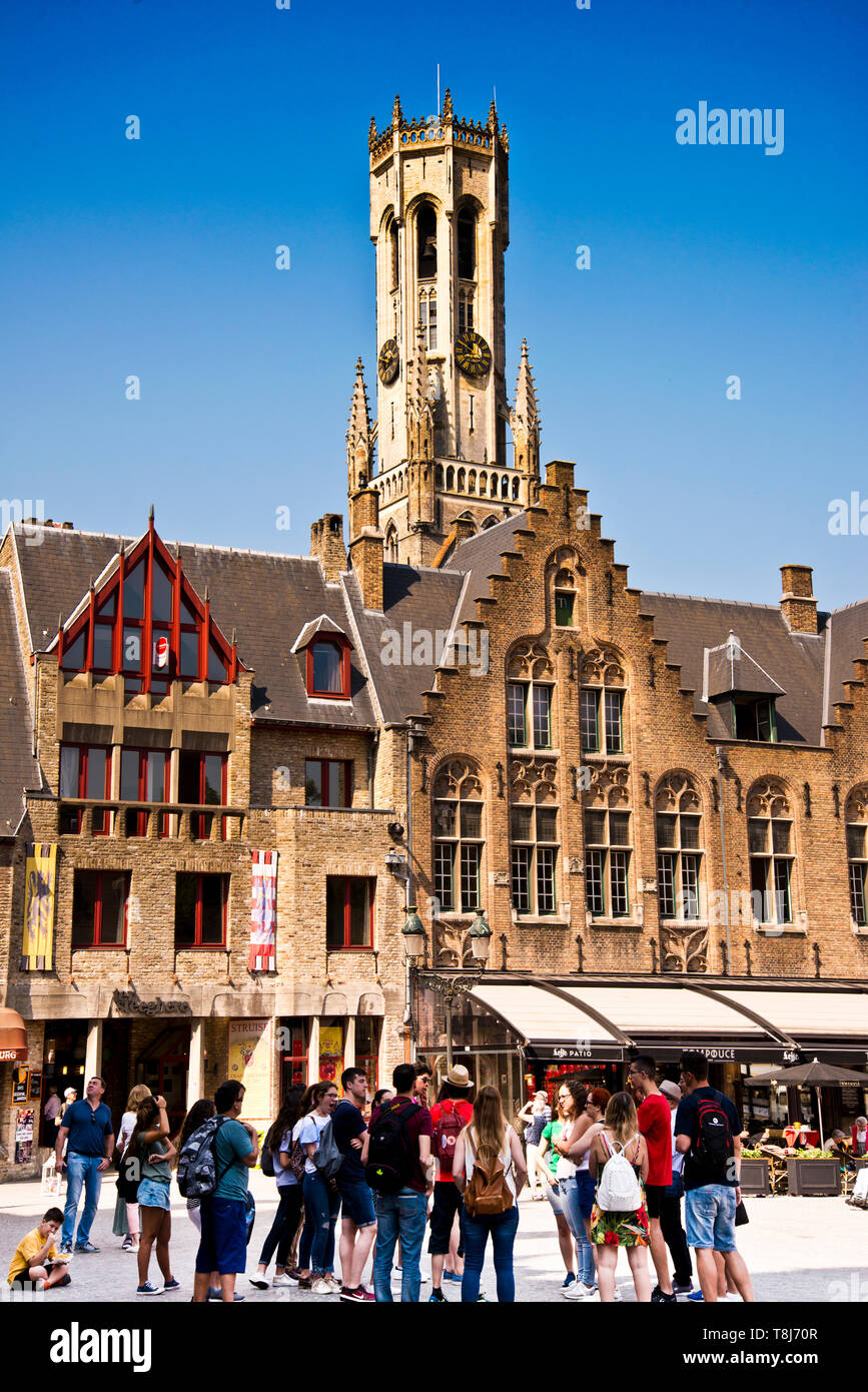 Gruppe junger Erwachsener, die zusammen auf einer geführten Tour durch die historische Altstadt von mittelalterlicher Architektur, Brügge, Belgien, Europa, stehen. Stockfoto