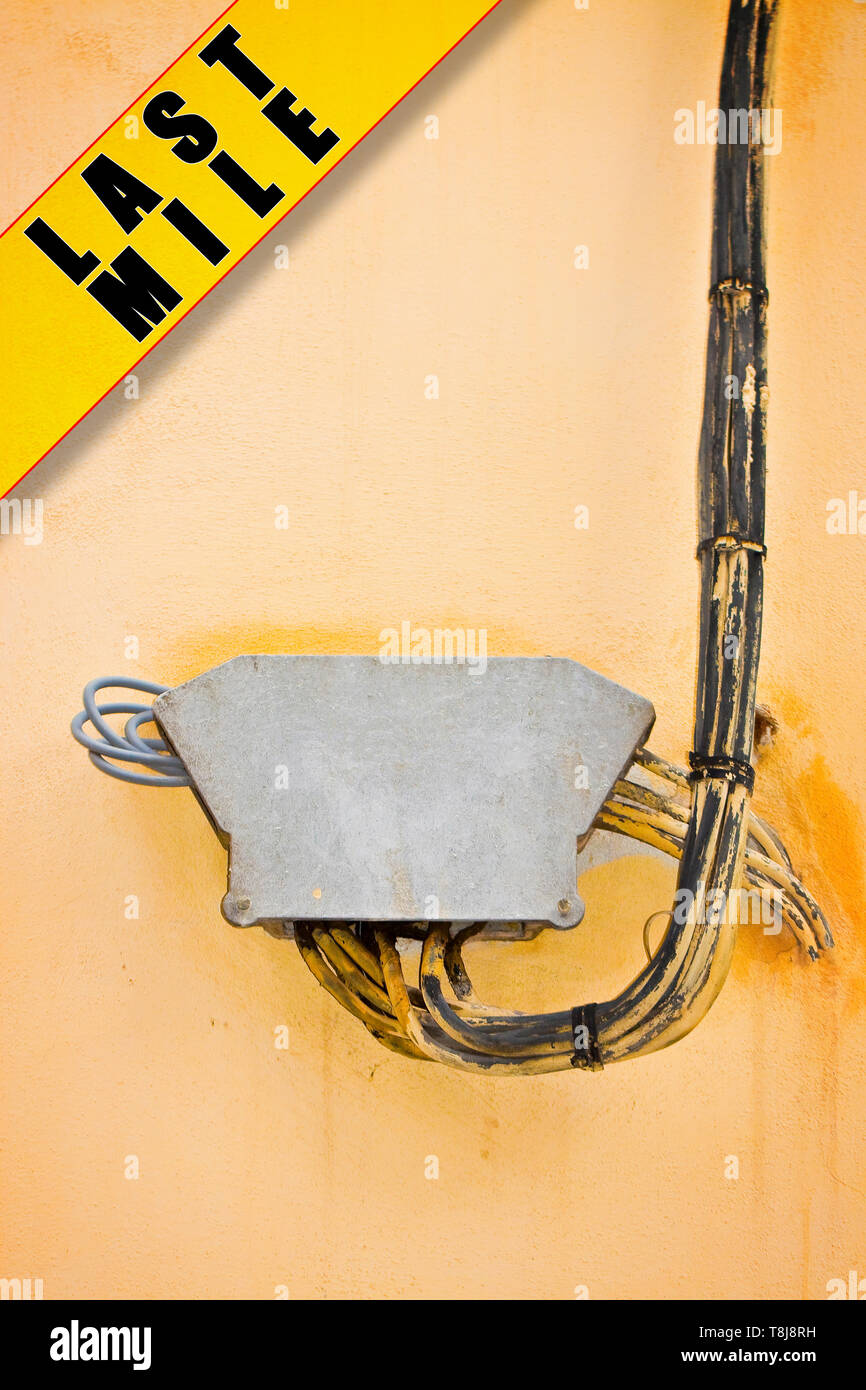 Elektrische Leitungen auf Putz an der Wand mit Schutz Anschlusskasten befestigt - Letzte Meile Konzept Bild Stockfoto