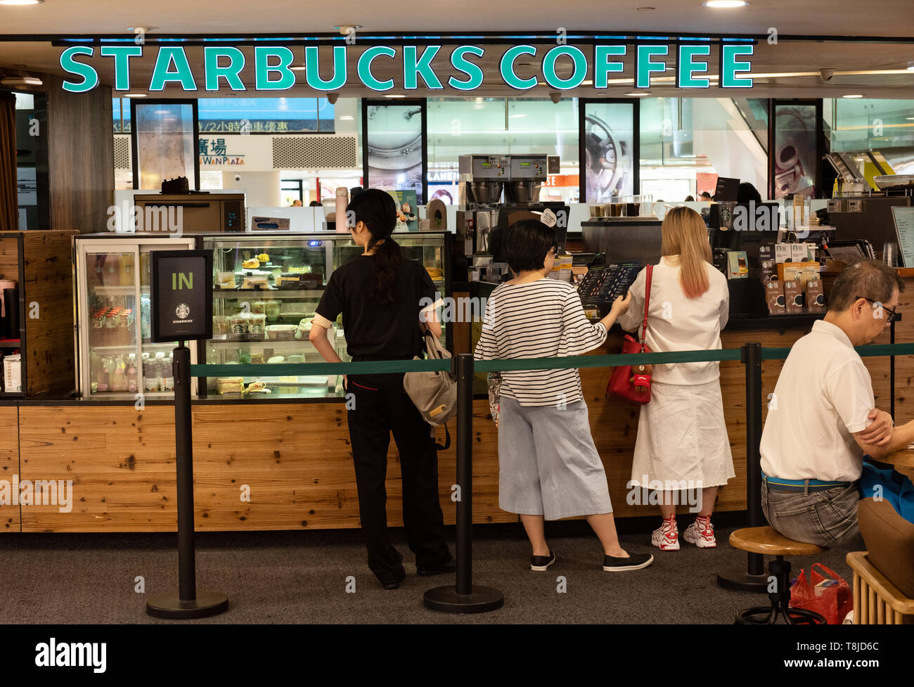 Kunden gesehen Einkauf Starbucks Kaffee an einem Einkaufszentrum in Hongkong. Stockfoto
