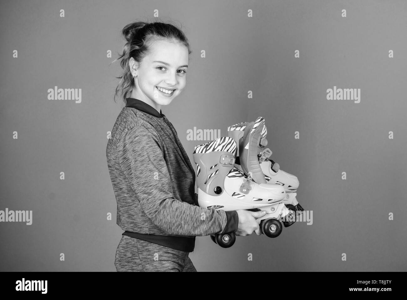 Ermöglicht die Fahrt. Mädchen süßes kleines Kind halten Rollschuhe. Hobby und aktive Freizeitgestaltung. Glückliche Kindheit. Die Einzugswalze skates Größe. Warum Kinder liebe Rollschuhe. Rollschuhe jedes Mädchen über das Träumen. Stockfoto