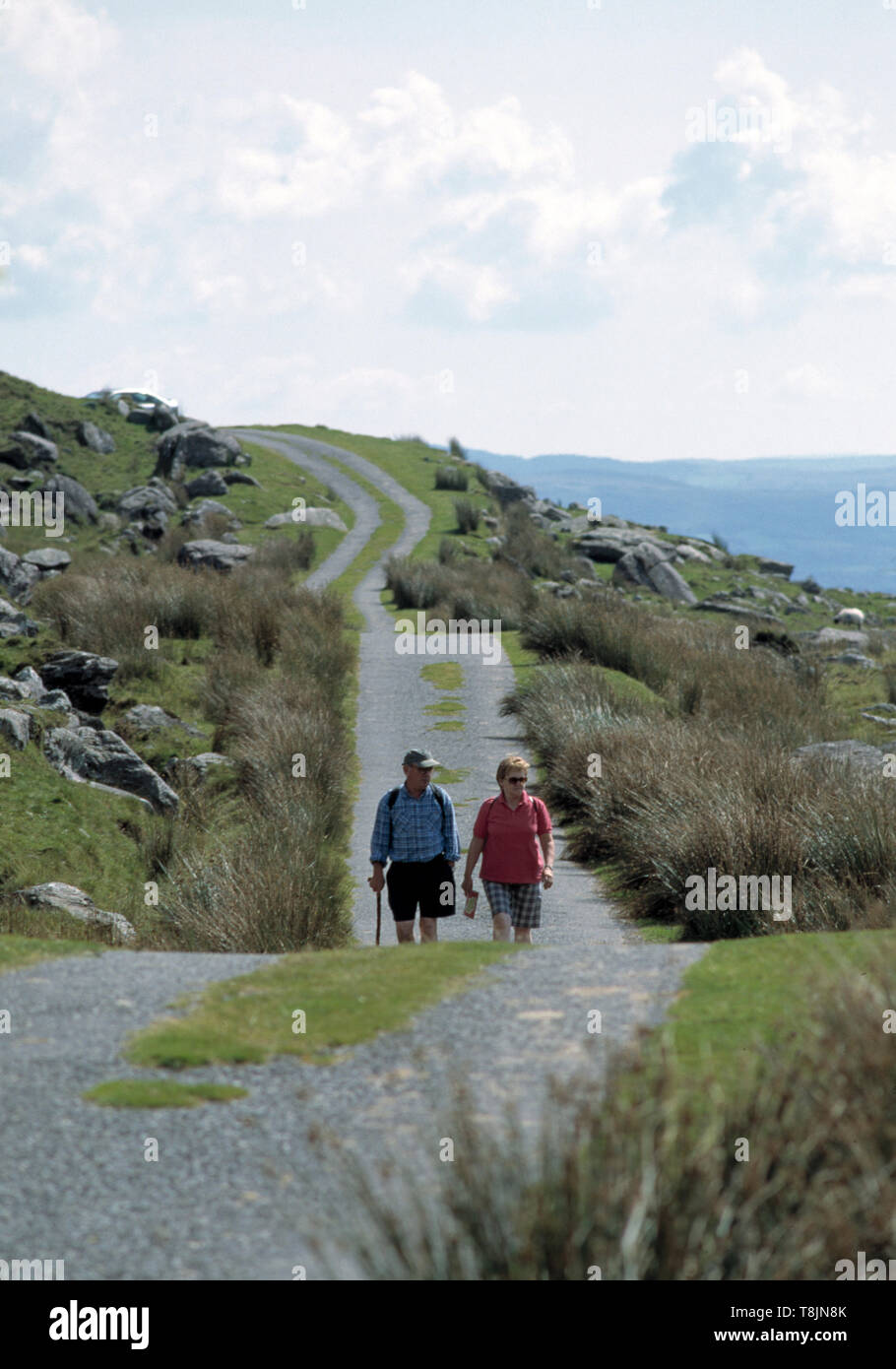 Zwei ältere Paare, die einen schmalen Pass auf den caha Bergen, Wild atlantic Way, County Cork, irland, wandern Stockfoto