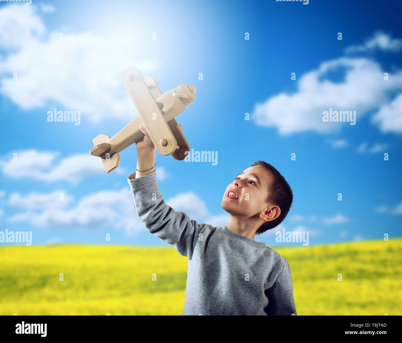 Kind spielt mit einem hölzernen Spielzeug Flugzeug Stockfoto