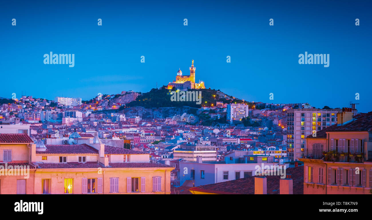 Marseille, Frankreich. Panoramablick auf das Stadtbild von Marseille mit der Kirche Notre-Dame de la Garde, Wahrzeichen der Stadt, auf einem Hügel bei Sonnenuntergang. Urlaub in Stockfoto