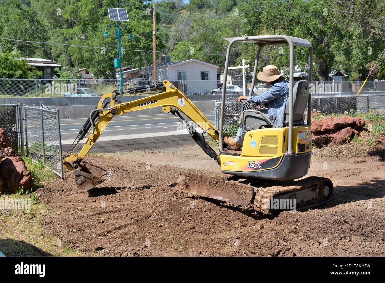 Verschieben von Felsen und der Installation von Rohrleitungen für die Landschaftsgestaltung, die von den mexikanischen Arbeiter mit Bagger und Handwerkzeuge für das Laden und Löschen von Partien in Lake County CA Stockfoto