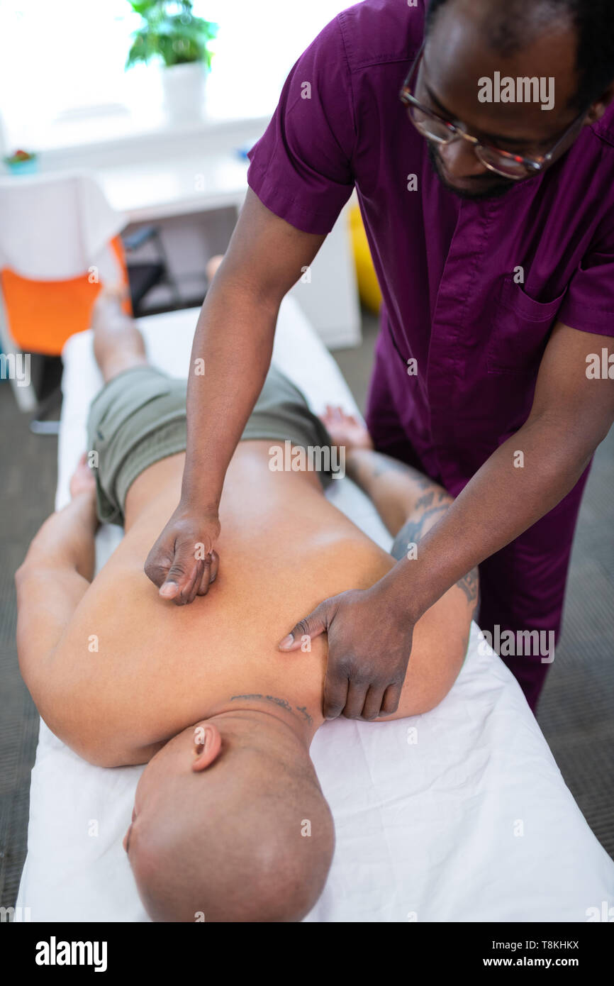 Dunkelhäutige massage Master zurück Massage für Sportler Stockfoto