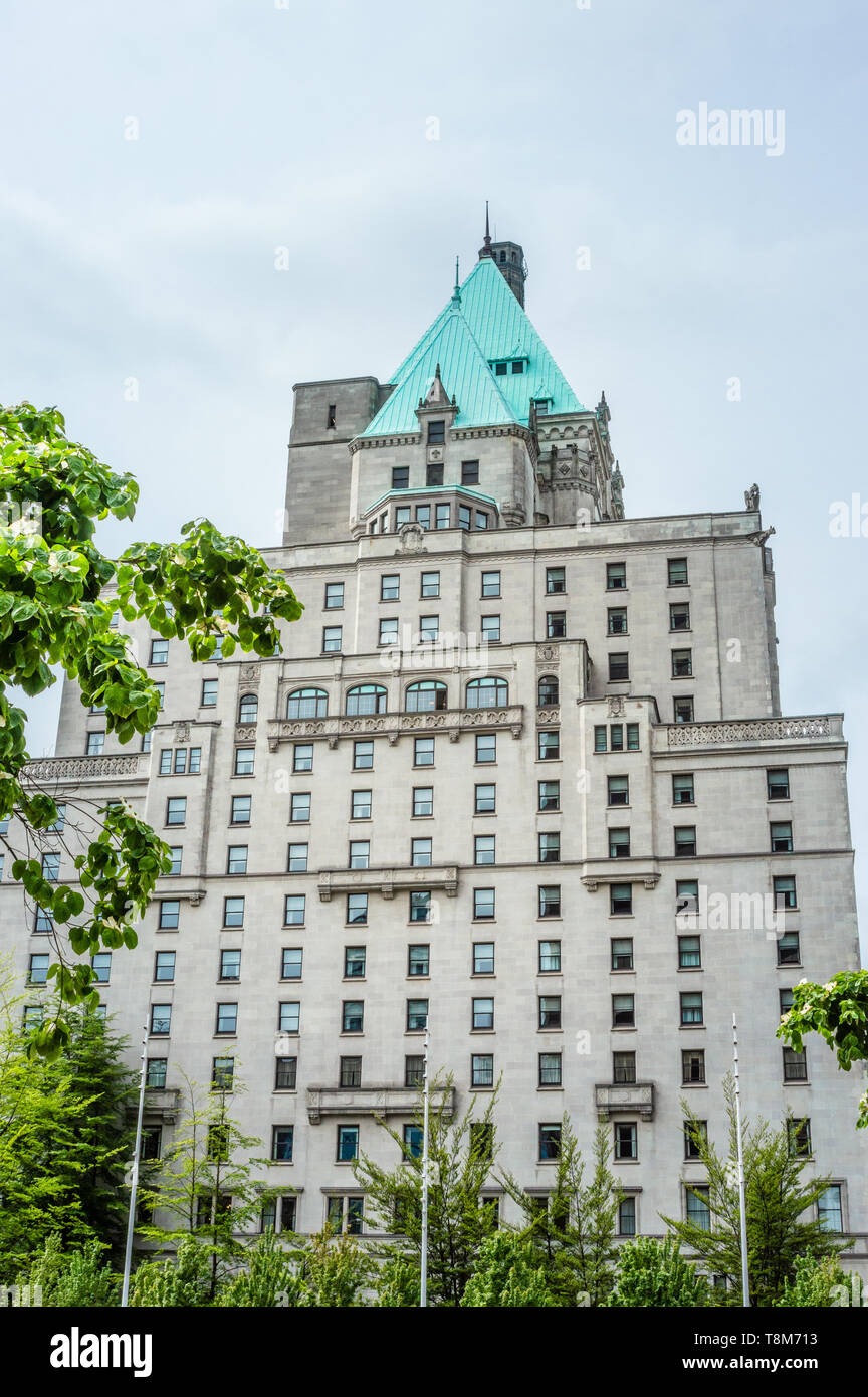 Hotel Vancouver Osten Fassade gegen bewölkten Himmel mit Frühling baum laub im Vordergrund. Stockfoto
