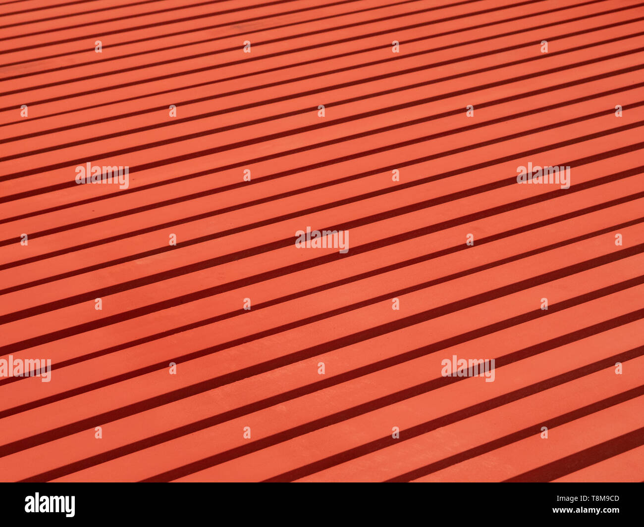 Rot lackiert Stahlträger auf dem Boden bilden ein lineares Muster. Stockfoto