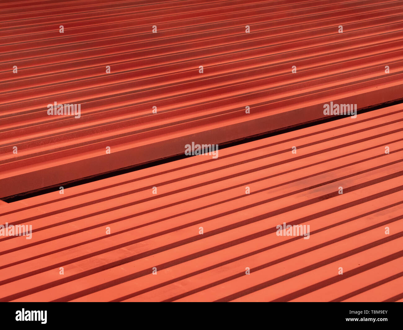 Rot lackiert Stahlträger auf dem Boden bilden ein lineares Muster. Stockfoto