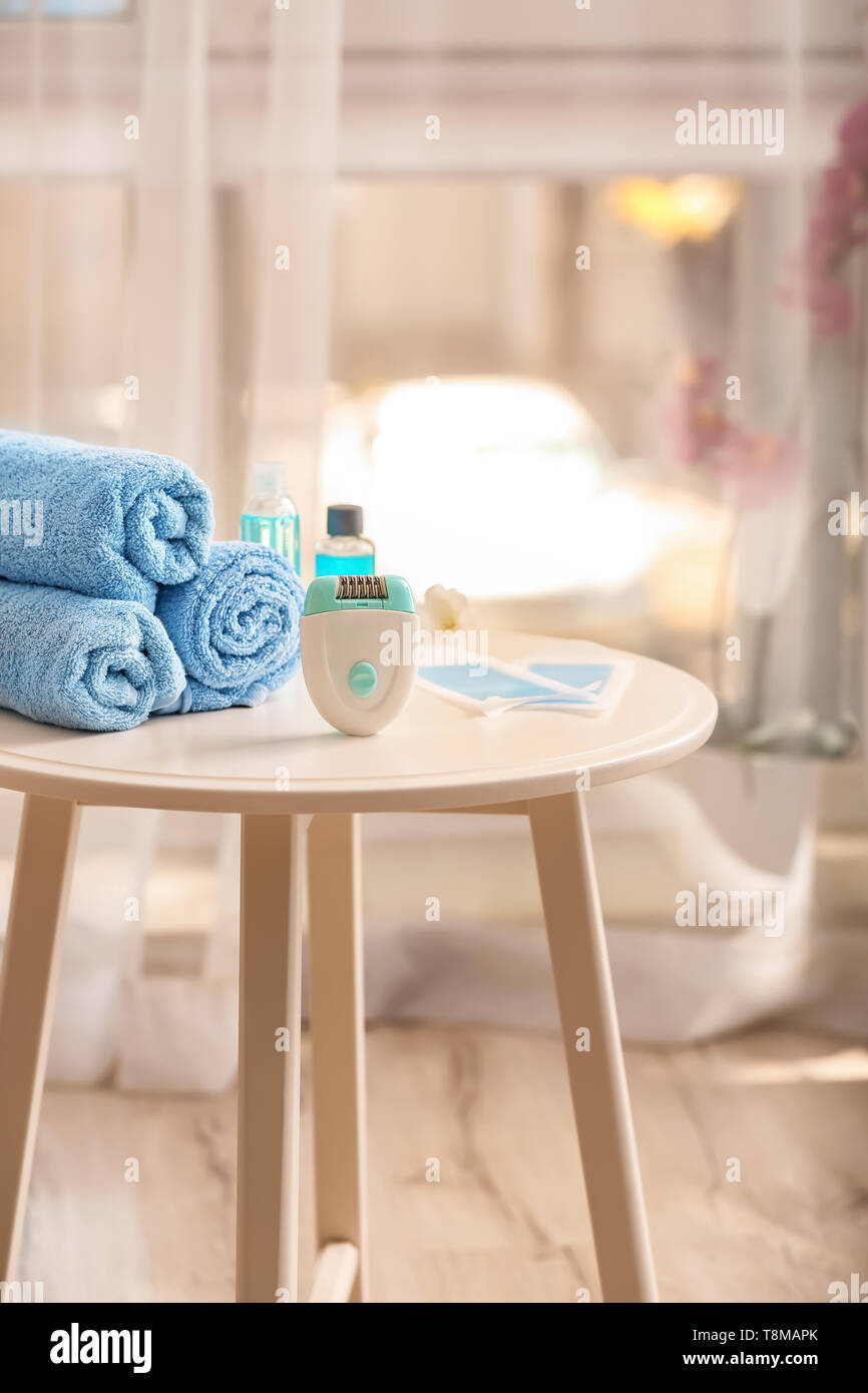 Moderne Epilierer, wachs Streifen und Handtücher auf Tisch Stockfoto