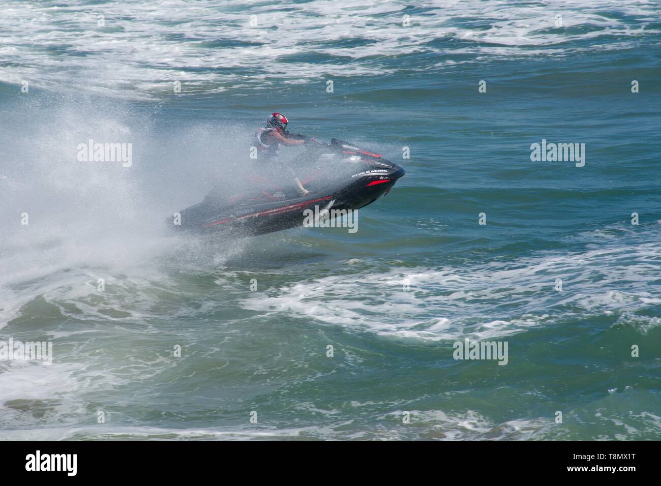 Huntington Beach, CA - 7. April 2019: Jet Skier reiten die Brandung in ein dramatisches Bild. Stockfoto