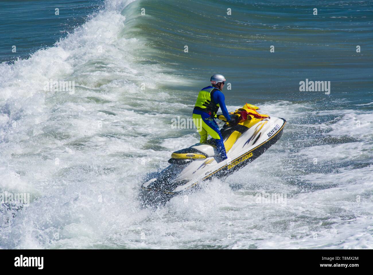 Huntington Beach, CA - 7. April 2019: Jet-Skifahrer steht im Jet-Ski auf, während er im Pazifik rast. Stockfoto