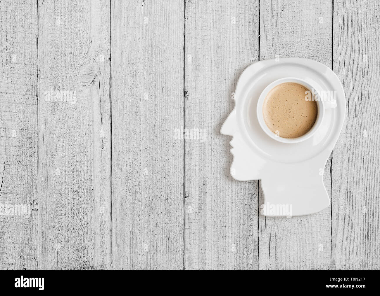 Kaffeetasse auf dem Teller in den menschlichen Kopf Form Stockfoto