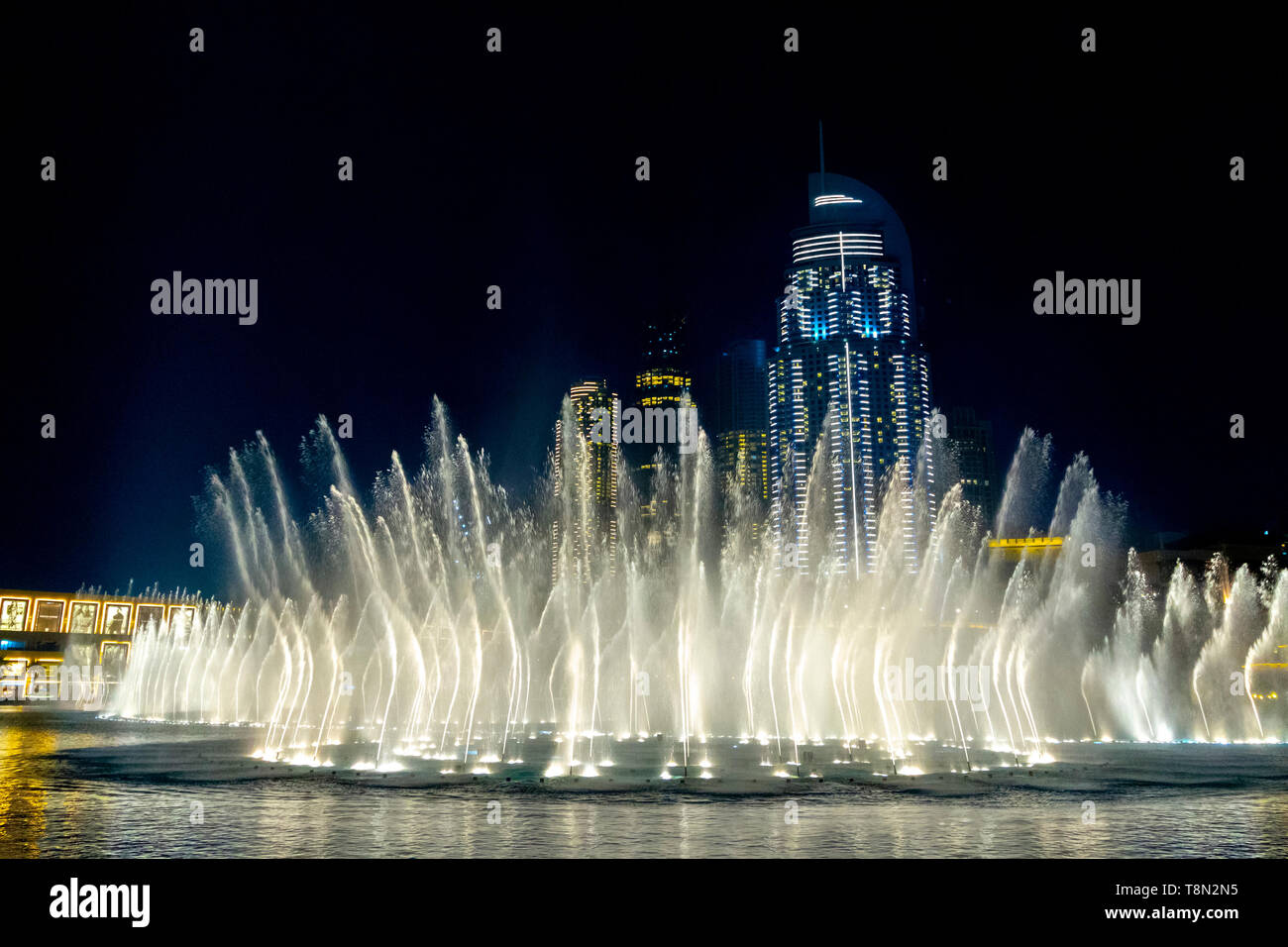 Brunnen mit Beleuchtung in der Mitte der Nacht Stadt Stockfotografie