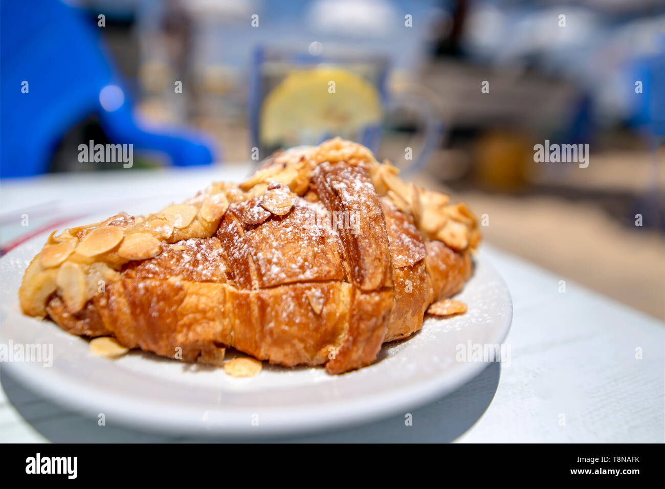 Croisson bestäubt mit Mandeln und Puderzucker close-up auf einem verschwommenen Hintergrund. Stockfoto