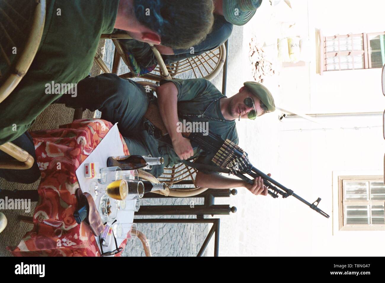 Ein kroatischer Soldaten wirft mit einem schweren Maschinengewehr in einem Cafe in der kroatischen Hauptstadt Zagreb im ehemaligen Jugoslawien während des Konflikts in den Jahren 1991-92. Bild von Adam Alexander Stockfoto