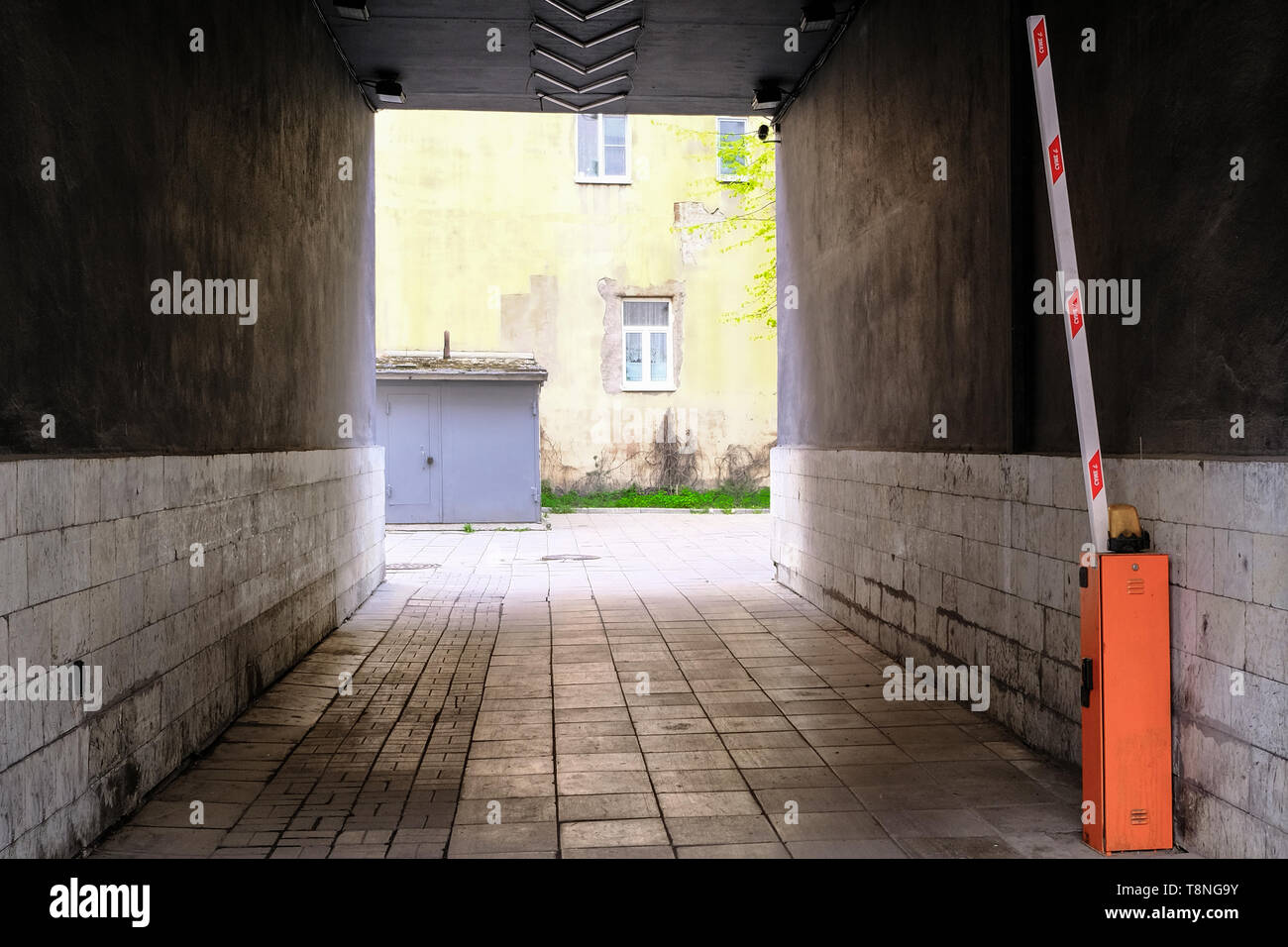Eine dunkle Gasse, die mit einem massiven Tor. Automatische Schranke Stockfoto