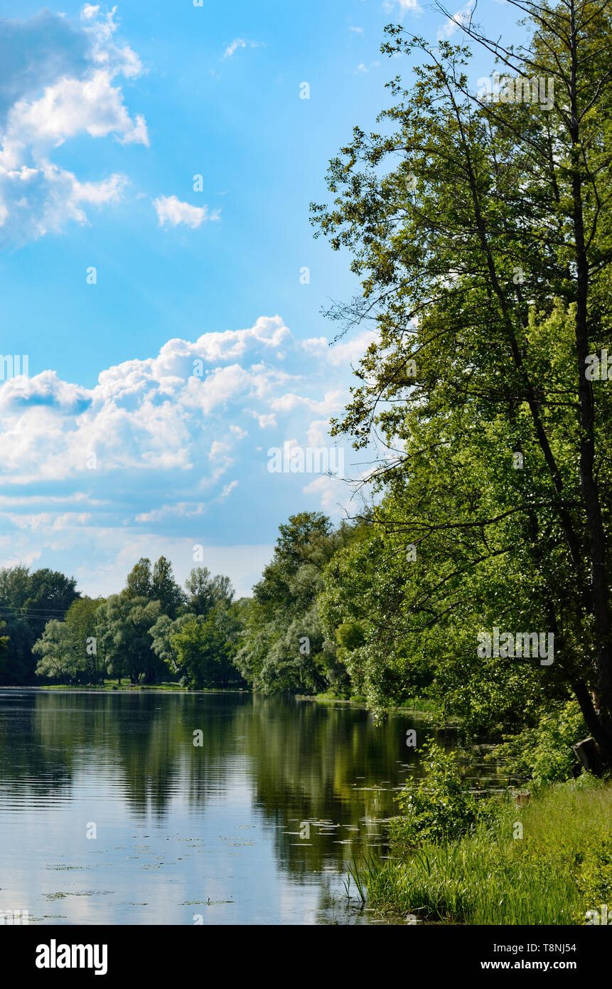Blick auf den See oder auf den Fluss Ufer unter blauen bewölkten Himmel Stockfoto