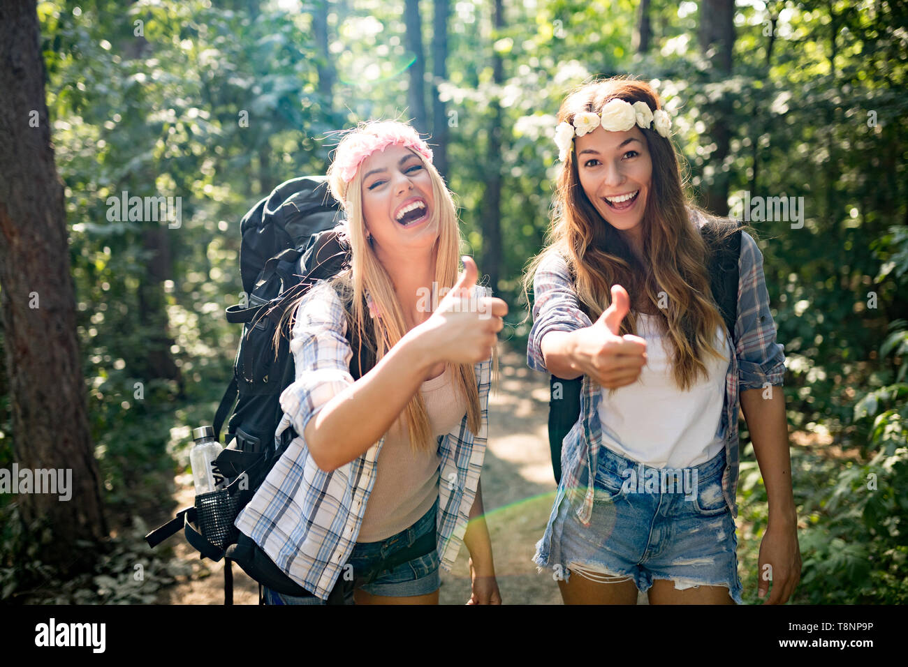 Abenteuer, Reisen, Tourismus, Wandern und Menschen Konzept. Glückliche Frau wandern mit Rucksäcken in den Wäldern Stockfoto