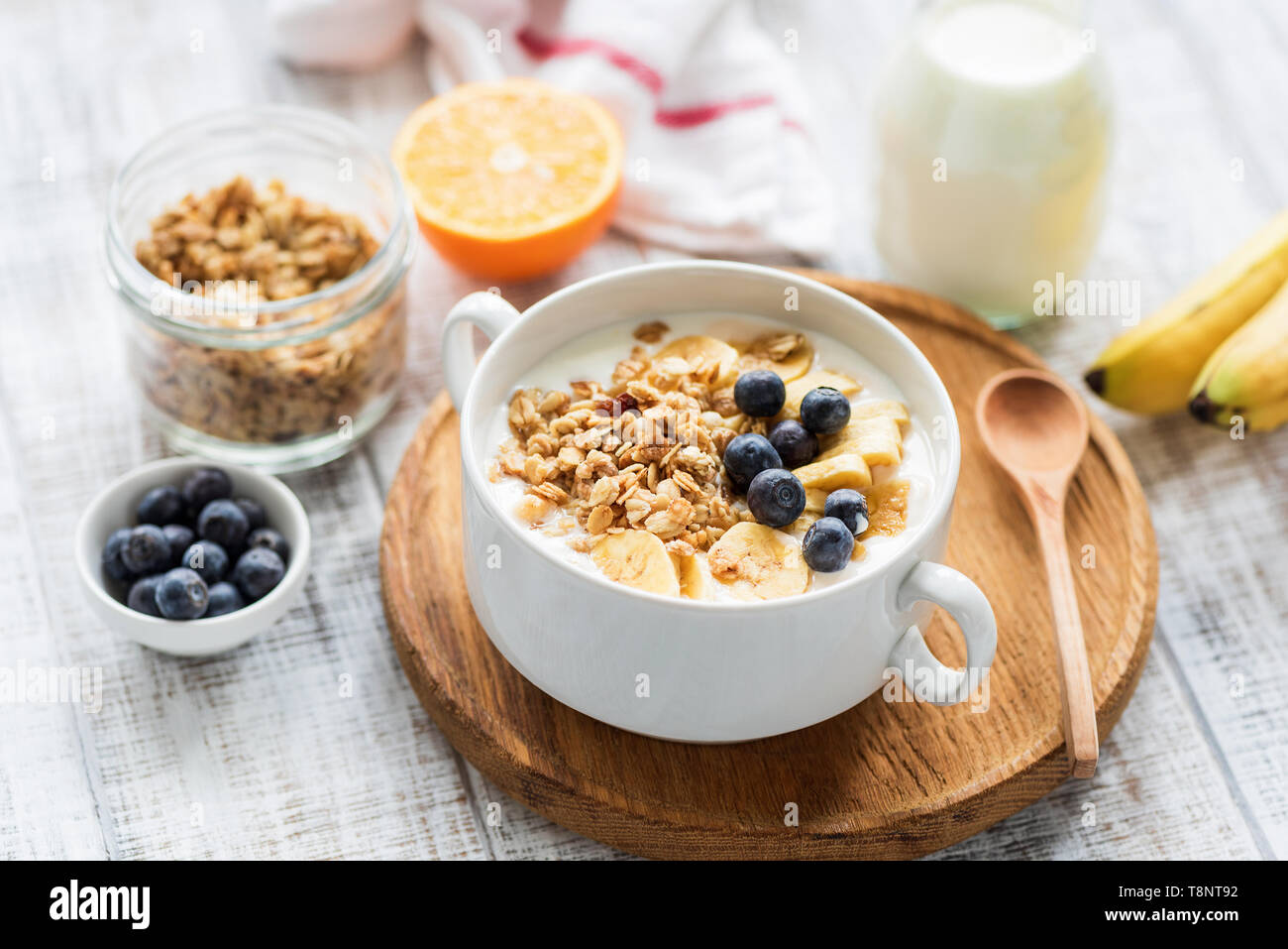 Müsli Schale mit Obst und Milch auf eine weiße Holztisch. Konzept der Gewichtsverlust, Diäten, gesunde Ernährung und Wohlbefinden Stockfoto