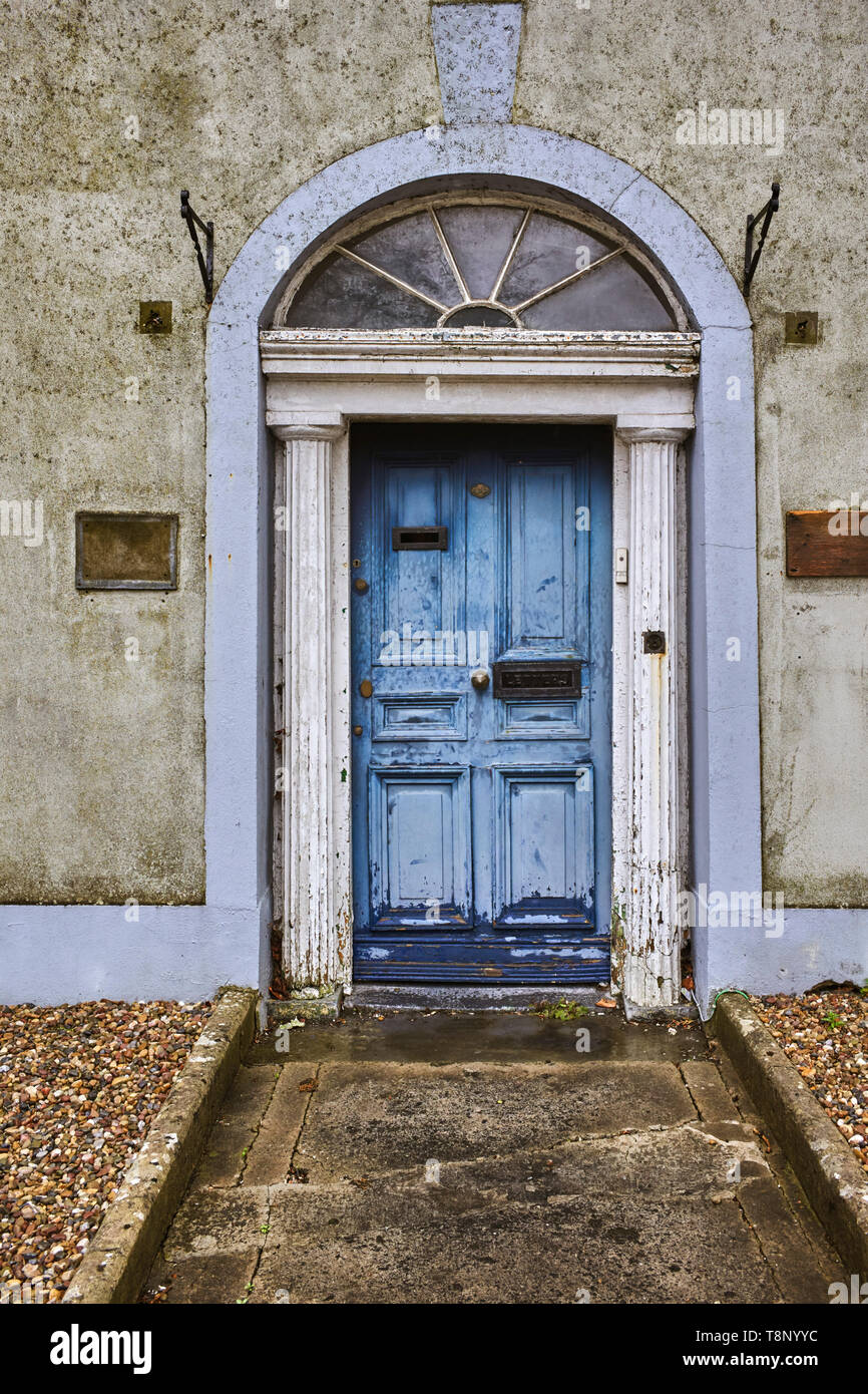 Ein heruntergekommenes Georgischen vordere Tür an einem Haus in Ennis, County Clare, Irland mit verblichenen Lackierung Stockfoto