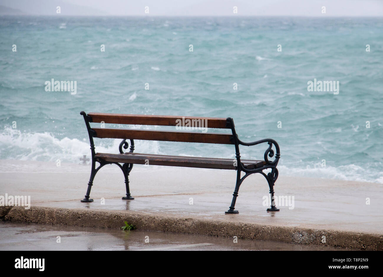 Leeren Bank durch die stürmische See von der Welle in Dalmatien Stadt am Meer in der Nebensaison bei starkem Südwind spritzte Stockfoto