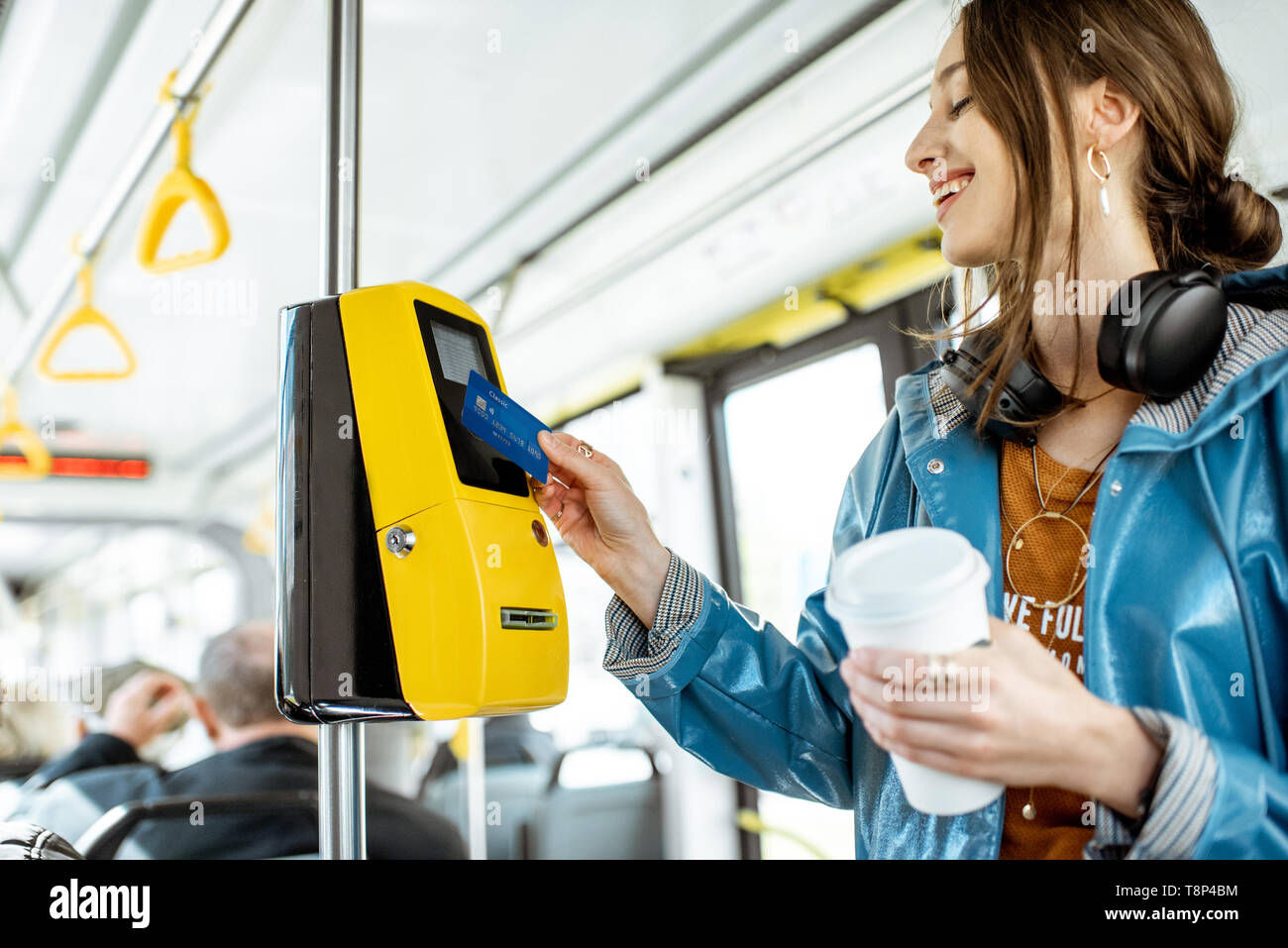 Frau Zahlung conctactless mit Bank Card für die öffentlichen Verkehrsmittel in der Straßenbahn Stockfoto