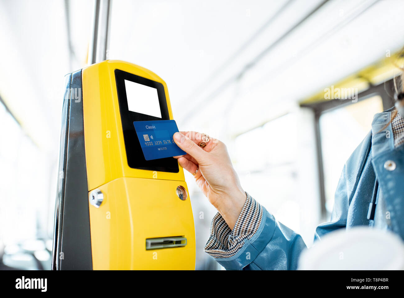Frau Zahlung conctactless mit Bank Card für die öffentlichen Verkehrsmittel in der Straßenbahn Stockfoto