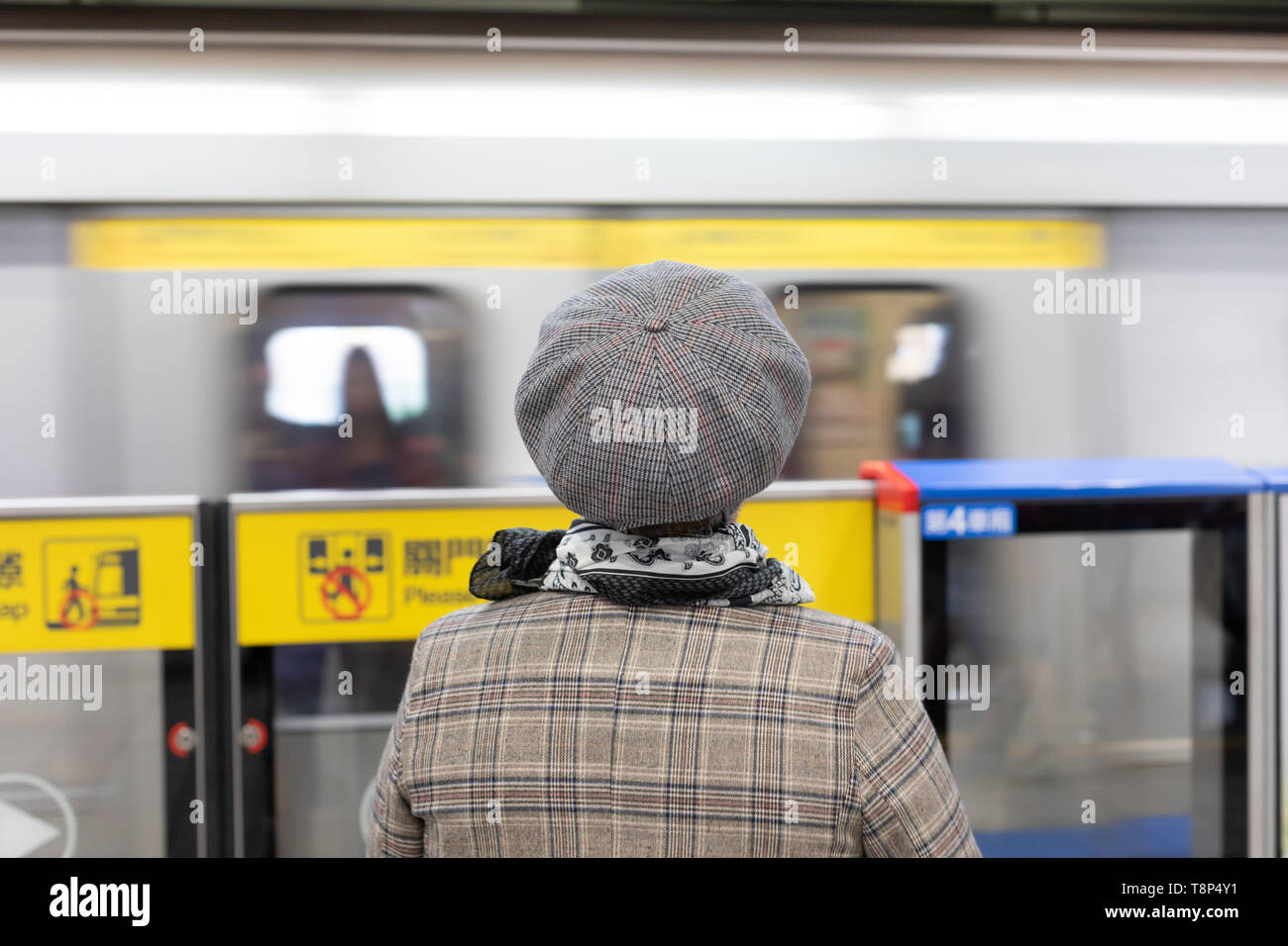 Frau warten auf die U-Bahn/U-Bahn/MRT in Taipei MRT Station, zurück zu Kamera Stockfoto