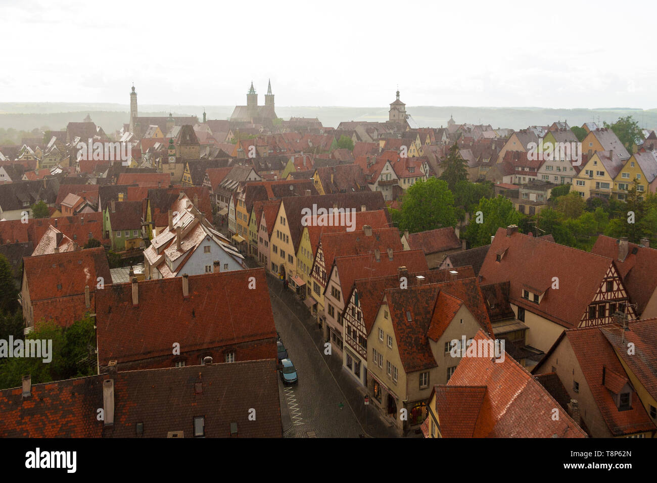 Luftbild der mittelalterlichen Rothenburg, seine Fachwerkhäuser & bunte Häuser am Rödergasse an einem regnerischen Tag. Am Horizont sichtbar: Rathaus... Stockfoto