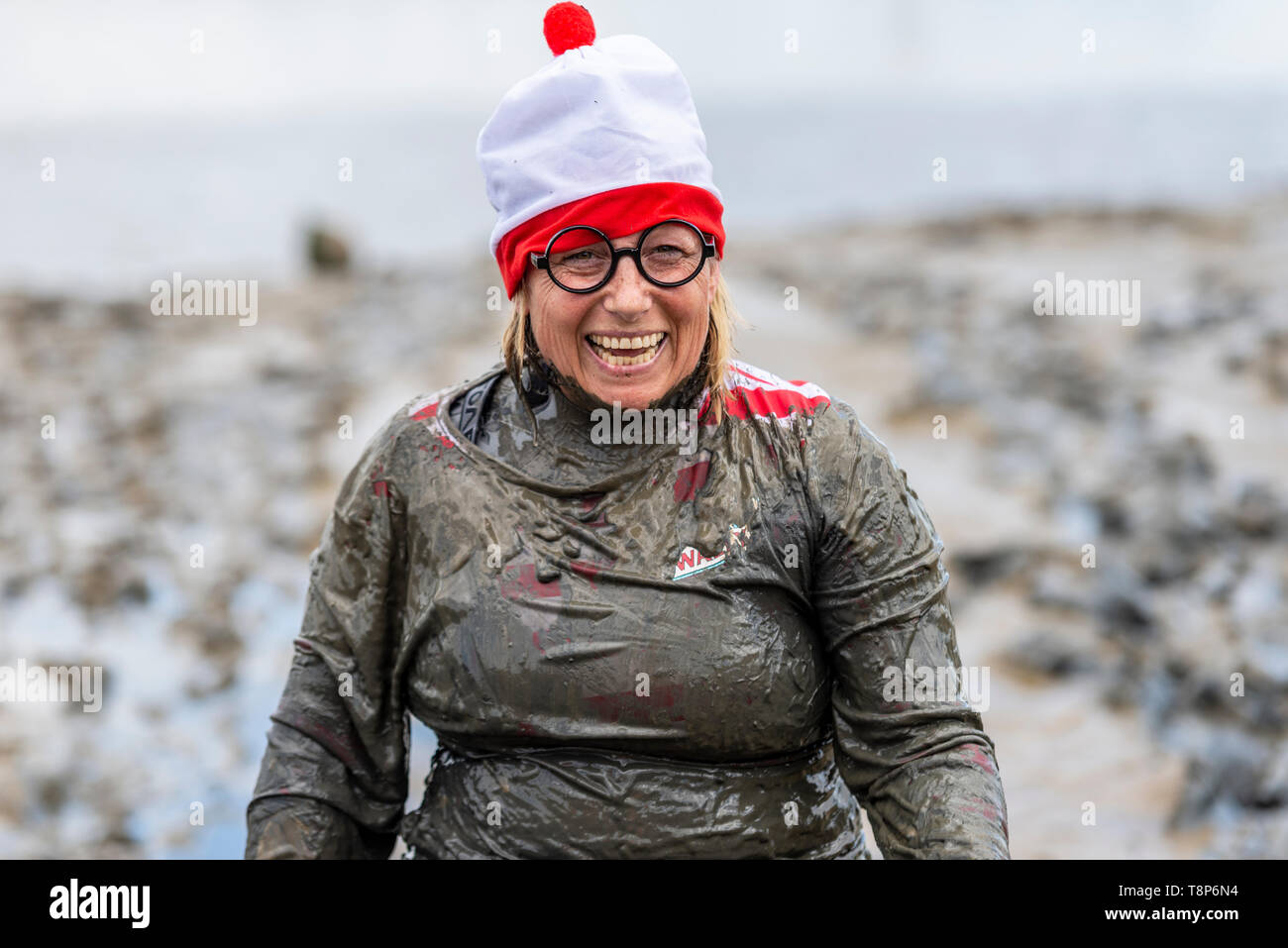 Weibliche in Wo ist Wally bobble Hut Kostüm an der Maldon Schlamm Rennen in den Fluss Blackwater, Maldon, Essex, Großbritannien. Stockfoto