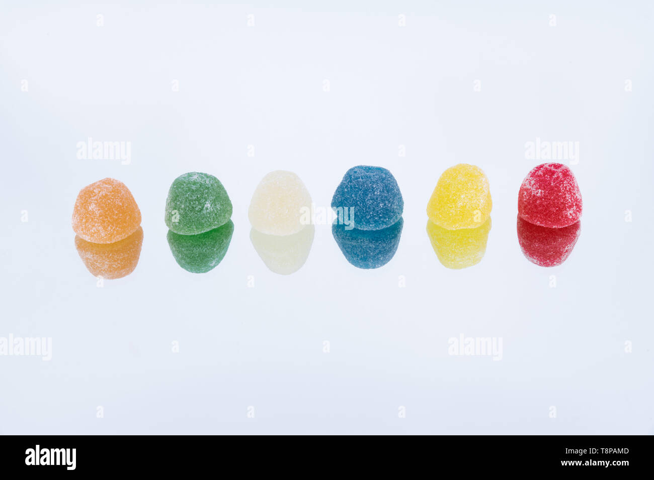 Linie von Süßigkeiten. Zucker überzogen Gelee Bonbons auf einfachen Hintergrund Stockfoto